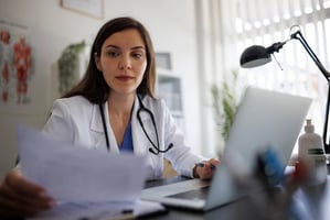 Doctor working at desk for article on medical records laws in texas