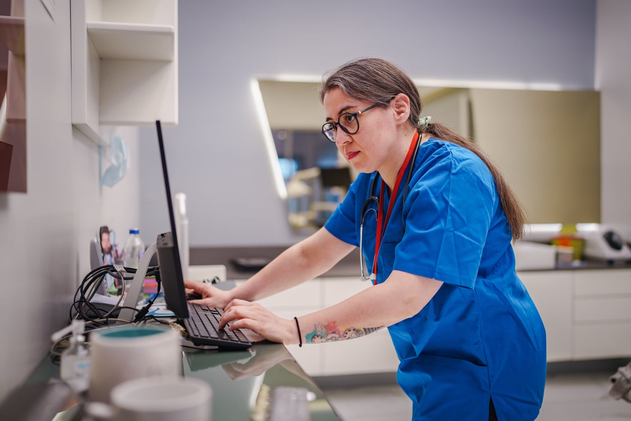 Healthcare provider using AI in a doctors’ office during daily clinical work.