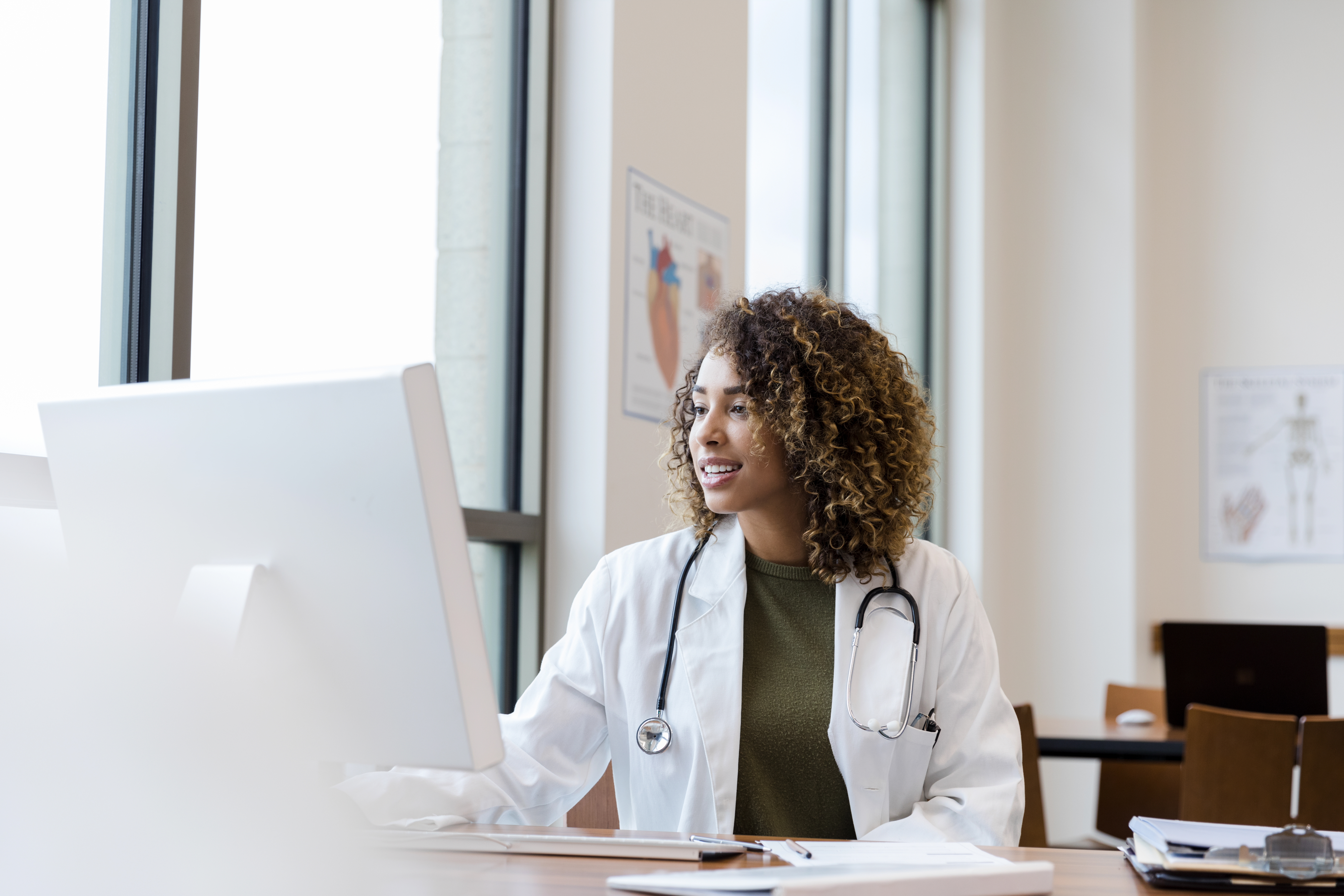 Physician looking at computer happy