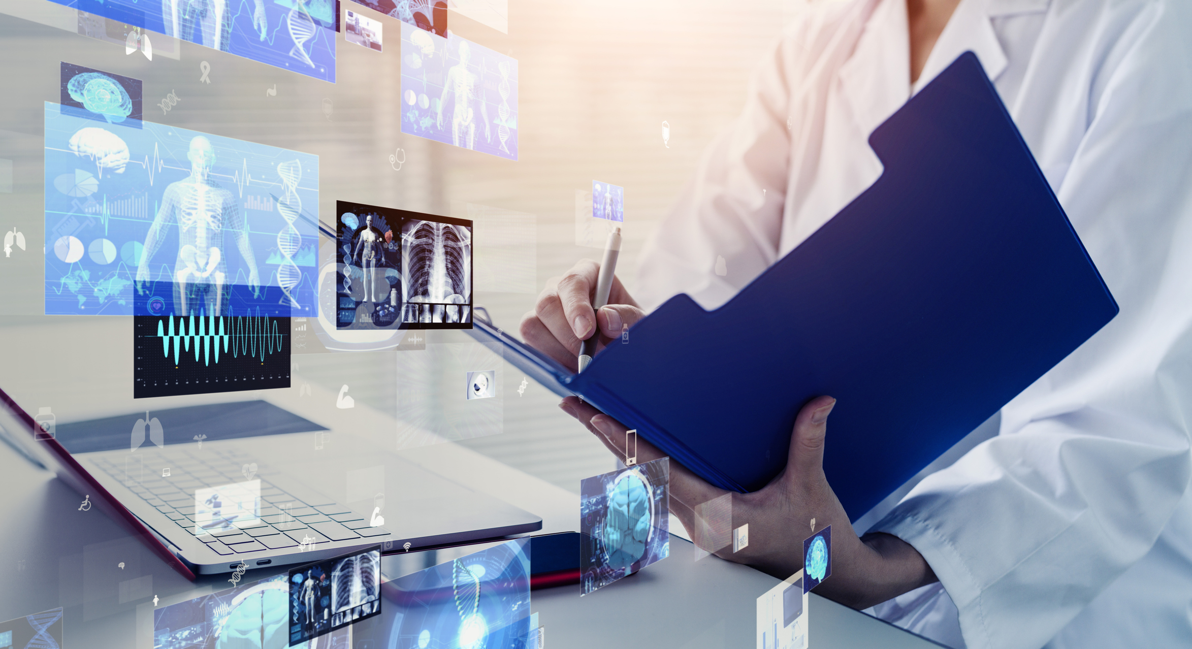 Doctor writing notes next to a computer. 6 tips for transitioning to a new EHR