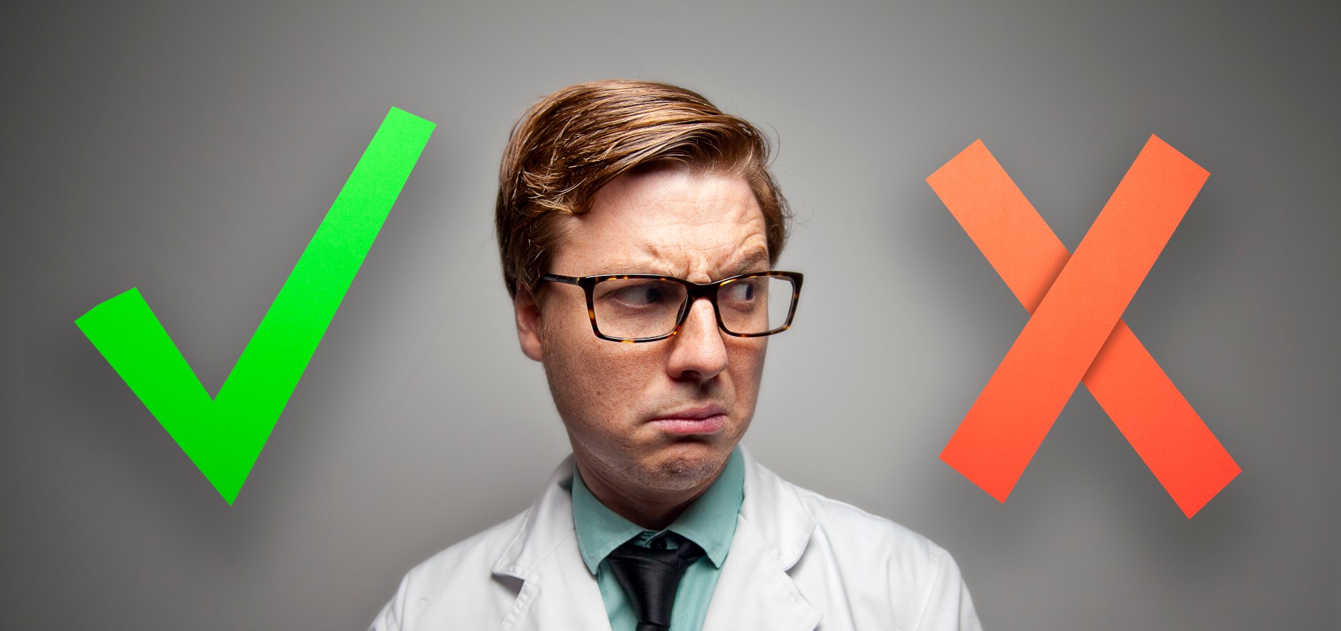 physician in a white lab coat looking at a red x instead of a green check box